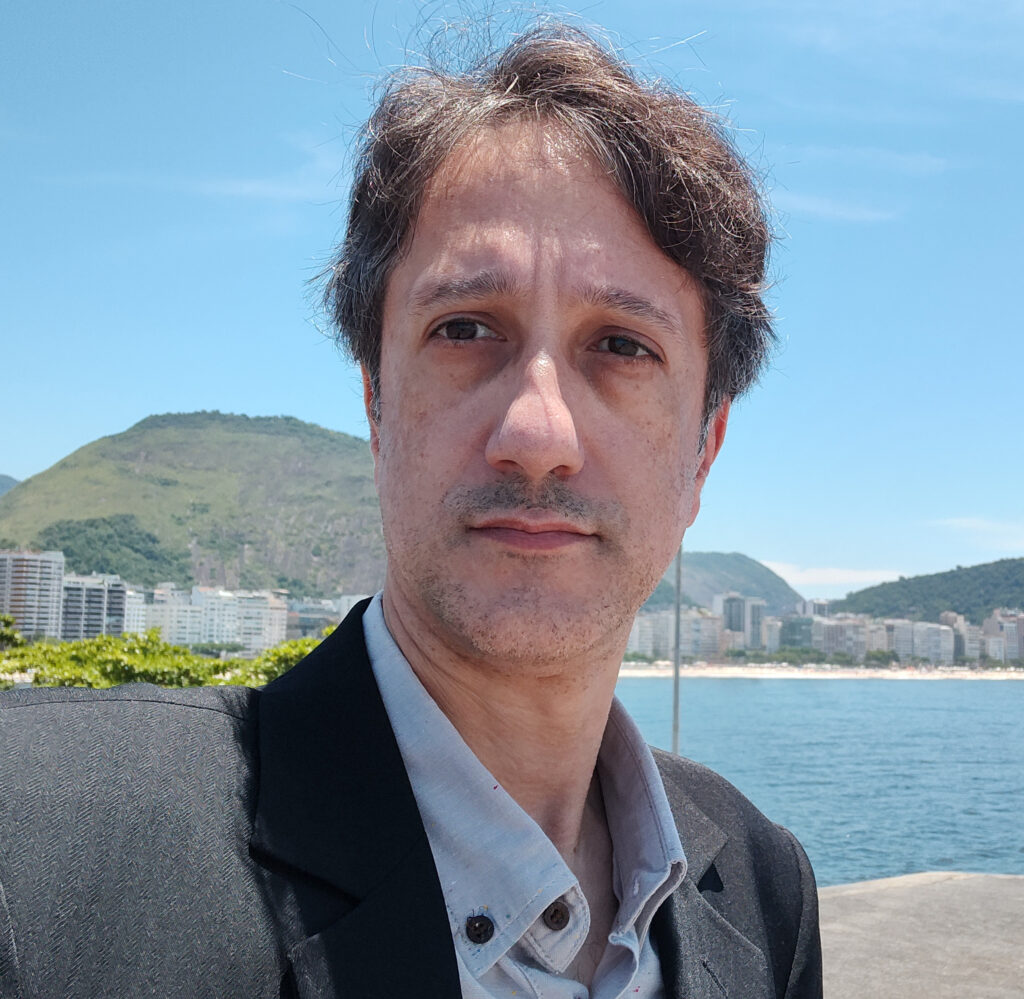 Roberto Cassano fingindo naturalidade enquanto derrete de terno sob o sol do Rio de Janeiro